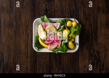 Paquet de salade avec Pickle turc, radis, persil et citron dans un coffret plastique contenant. L'alimentation biologique. Banque D'Images