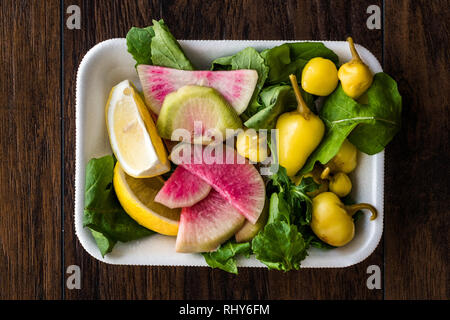 Paquet de salade avec Pickle turc, radis, persil et citron dans un coffret plastique contenant. L'alimentation biologique. Banque D'Images