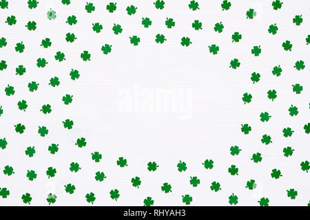 St Patrick's Day background. Quatrefoils vert sur la surface en bois blanc avec de l'espace libre pour le texte, round frame border Banque D'Images