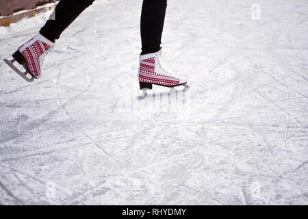 Girl riding sur une patinoire. La glace et patins. Les pieds dans l'homme skates Banque D'Images