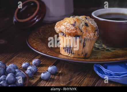 Blueberry muffin et tasse de café sur une plaque avec les bleuets sur un fond de bois foncé Banque D'Images