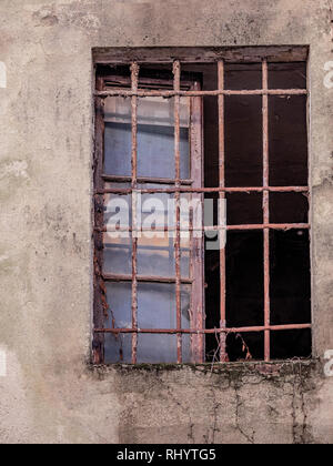 Fenêtre d'un vieux bâtiment inhabité avec rusty bars Banque D'Images