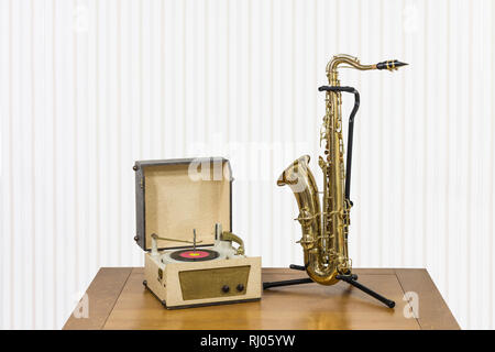 Ancien record player et saxophone sur table en bois. Banque D'Images