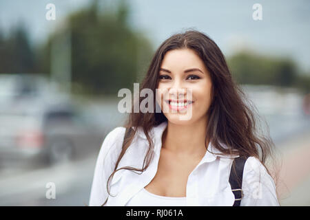 Belle brune standing outdoors and smiling Banque D'Images