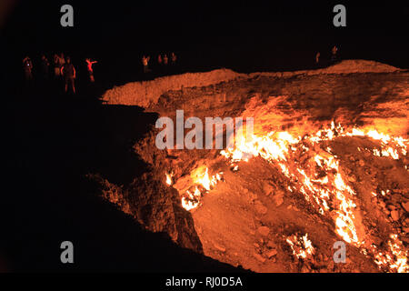 Les gens qui regarderaient et posaient pour prendre des photos au cratère de Darvasa, également connu sous le nom de Doorway to Hell, le cratère à gaz flamboyant dans Darvaza Turkménistan Banque D'Images