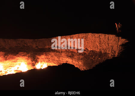 Les gens qui regardaient le cratère de Darvasa, également connu sous le nom de Doorway to Hell, le cratère à gaz flamboyants à Darvaza (Darvasa), au Turkménistan Banque D'Images
