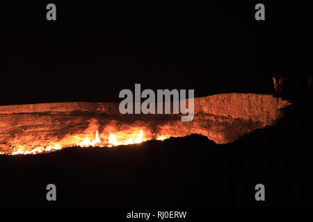 Les gens qui regardaient le cratère de Darvasa, également connu sous le nom de Doorway to Hell, le cratère à gaz flamboyants à Darvaza (Darvasa), au Turkménistan Banque D'Images
