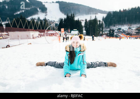 Belle fille dans une veste de ski promenades sur un jour de printemps ensoleillé dans les montagnes. Banque D'Images