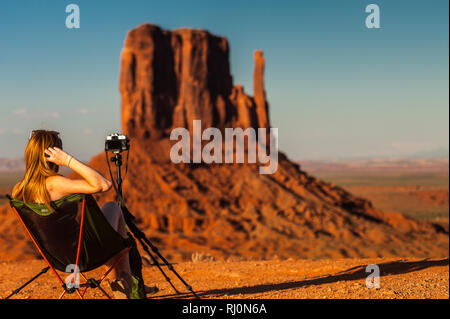 Un jeune photographe en attendant le coucher du soleil en face de la butte de Monument Valley, Arizona, États-Unis d'Amérique, Amérique du Nord Banque D'Images