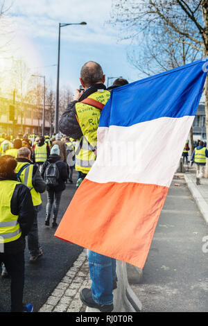 STRASBOURG, FRANCE - DEC 02, 2018 : l'homme avec drapeau national français à la recherche à des centaines de gilets jaunes Gilet jaune manifestation de protestation au cours de Strasbourg Banque D'Images