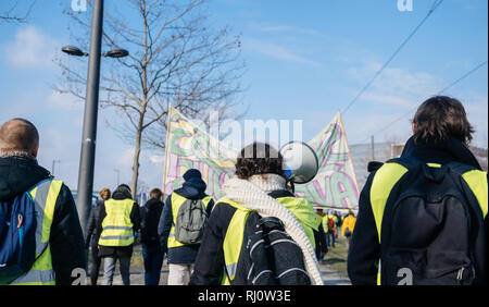 STRASBOURG, FRANCE - DEC 02, 2018 : femme hurlant sur haut-parleur mégaphone démontrant marchant avec des pancartes de protestation au cours de gilets jaunes Gilet jaune manifestation Parlement Européen Banque D'Images