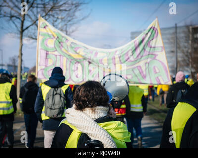 STRASBOURG, FRANCE - DEC 02, 2018 : femme hurlant sur haut-parleur mégaphone démontrant marchant avec des pancartes de protestation au cours de gilets jaunes Gilet jaune manifestation Parlement Européen Banque D'Images