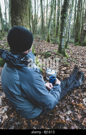 Un homme assis dans les bois. Banque D'Images