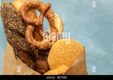 Différents types de pâte avec l'arrière-plan flou, assortiment de viennoiseries, pain, bretzel, baguette, croissant, brioches close up, selective focus Banque D'Images