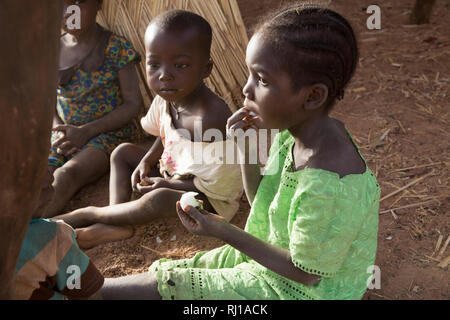 Village de samba, Province de Yako, Burkina Faso : les enfants de manger des fruits. Banque D'Images