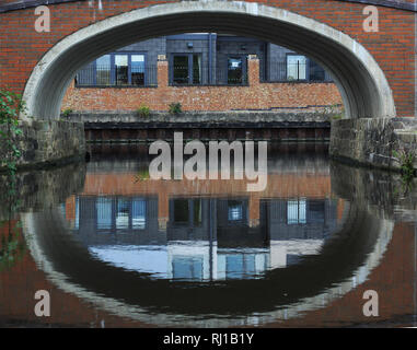 Arched bridge over canal avec des bâtiments industriels Banque D'Images