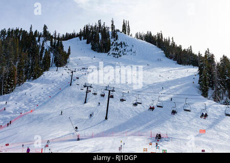 À Squaw Valley Ski Resort de Placer County, Californie. Les gens sur un télésiège, le ski alpin et le ski de bosses un terme. Banque D'Images