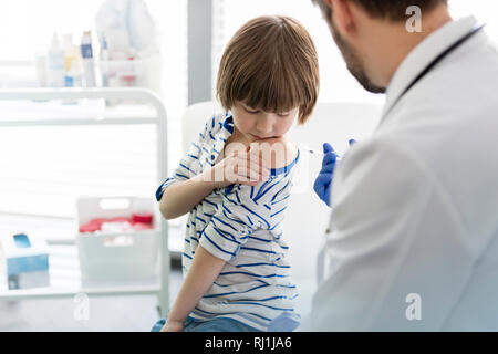 Young doctor injecting garçon à l'hôpital Banque D'Images