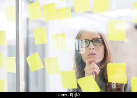 Young businesswoman thinking en regardant de droit Banque D'Images