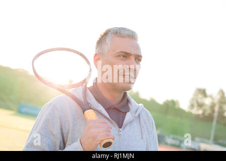 Retour allumé de certain couple avec raquette de tennis sur le court contre ciel clair Banque D'Images