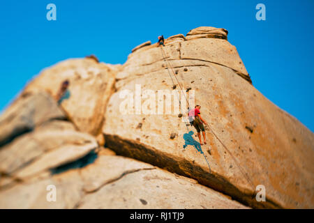 Faible angle de vue de deux grimpeurs escalade en montagne. Banque D'Images