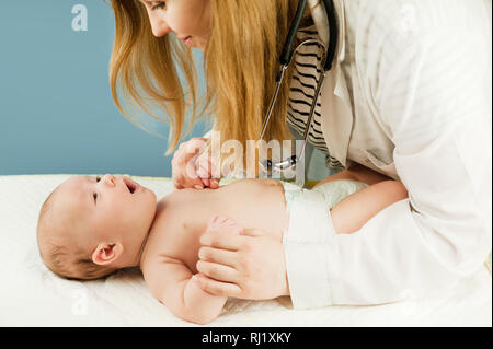 Médecin faisant des exercices avec un nonborn bébé sur un fond isolé. Concept de la médecine et de la santé Banque D'Images