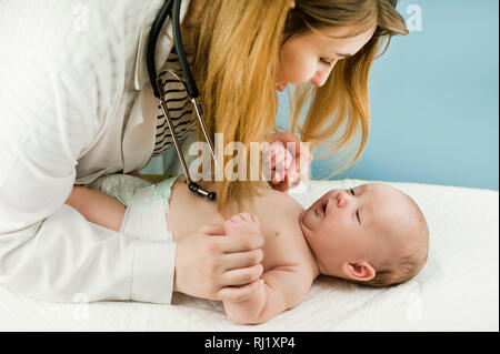 Médecin faisant des exercices avec un nonborn bébé sur un fond isolé. Concept de la médecine et de la santé Banque D'Images