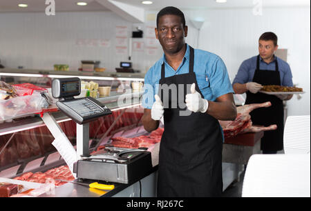 Portrait de satisfait African American male boucher professionnel en boucherie Banque D'Images