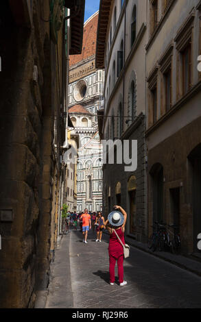 Tourisme photographiant la cathédrale de Florence (Duomo) d'une rue latérale de la Piazza del Duomo, Florence, Italie Banque D'Images