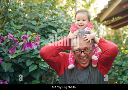 Heureux grand-père et sa petite-fille jouer sur sunny park background Banque D'Images