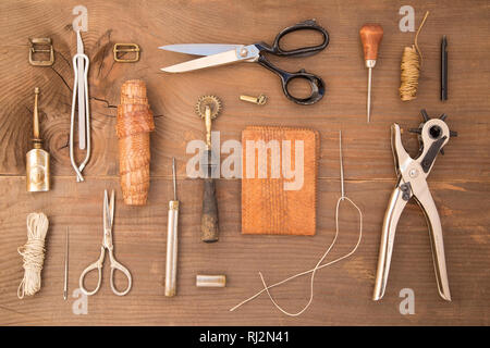 Outils d'artisanat du cuir sur un fond de bois Banque D'Images