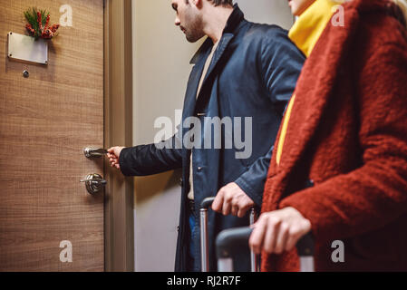 Entrez dans la chambre d'hôtel. Jeune couple près de l'entrer dans la chambre d'hôtel avec leurs bagages et d'avoir un chat. Close-up Banque D'Images