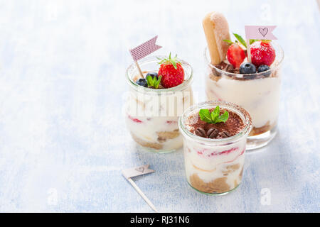 Tiramisu dessert italien fait maison avec des fraises, de menthe et de cacao dans des bocaux en verre, gros plan Banque D'Images