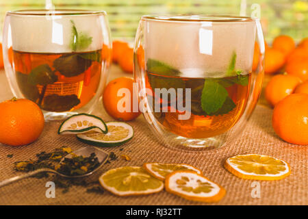 Tasses de Thé chaud avec du citron et menthe, et avec quelques fruits secs sur une table de cuisine fermer la fenêtre Banque D'Images