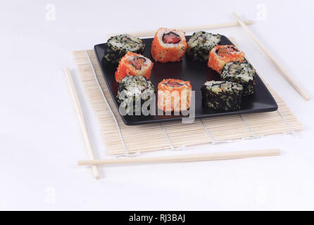 Différents types de Maki sushi sur une plaque noire Banque D'Images