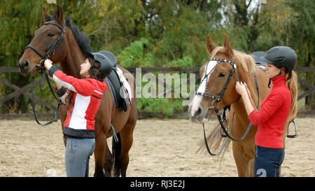 Deux filles de la préparation des chevaux pour monter au ranch. Banque D'Images