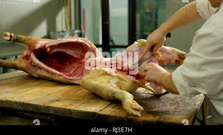 Des coupes de la carcasse de porc boucher dans un abattoir. Banque D'Images