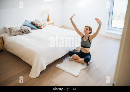 Une jeune femme faisant de l'exercice à l'intérieur dans une chambre à coucher. Copier l'espace. Banque D'Images