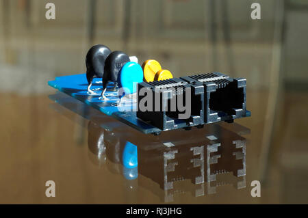 Pièce de matériel électronique - noir, bleu et jaune des composants électroniques montés sur circuit imprimé PCB - avec les prises téléphoniques en réseau ou Banque D'Images