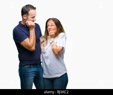 L'âge moyen hispanic casual couple sur fond isolé à souligné et nerveux avec les mains sur la bouche de mordre les ongles. Problème d'anxiété. Banque D'Images