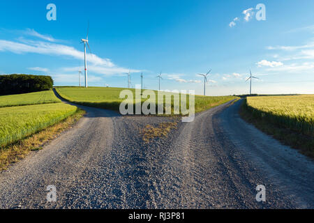 Champ fourchue chemin dans la campagne avec des éoliennes au printemps, Retzstadt, Wurzburg, Franconia, Bavaria, Germany Banque D'Images