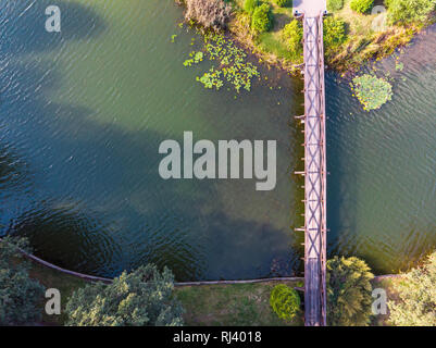 Vue de dessus de l'antenne de pont de bois sur l'étang de l'eau bleu reliant deux îles, des reflets dans l'eau Banque D'Images