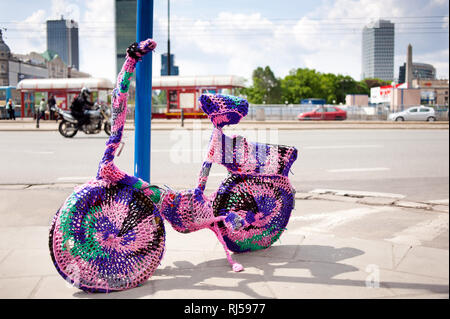 Location de guérilla rose, tricot de fils multicolores décoration sur le vélo sur la chaussée gauche dans le centre de Varsovie, Pologne, Banque D'Images