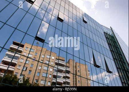 Gratte-ciel moderne avec paroi en verre et des fenêtres et des réflexions avec l'ancien bloc d'appartements, low angle view, Varsovie, Pologne, Europe, Banque D'Images