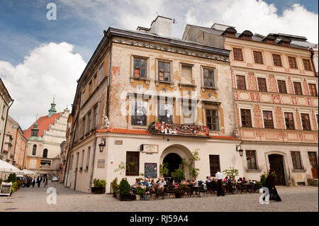 Ancien restaurant juif Mandragora délabré à Lublin, Pologne, la vieille ville, les touristes assis et de manger à l'extérieur des portes avant et des piétons circulent sur w Banque D'Images