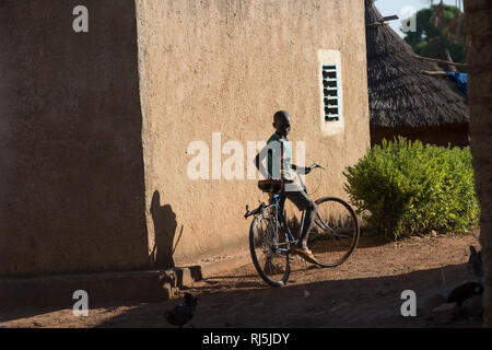 Village de Bodadigou, Banfora, région des Cascades, Burkina Faso, 4 décembre 2016; un garçon sur son vélo à travers le village. Banque D'Images