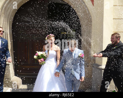 Les nouveaux mariés sont jetés avec du riz à la sortie de la cérémonie de mariage Banque D'Images