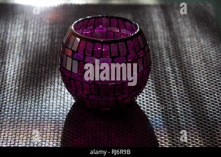 Support de bougie en forme de boule constituée de petits verres de couleur dans l'après-midi la lumière. Banque D'Images