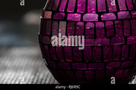 Détail de ball shaped candle holder constituée de petits verres de couleur dans l'après-midi la lumière. Banque D'Images