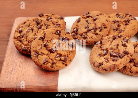 Des cookies au chocolat brun doré sur un fond de bois rustique foncé Banque D'Images